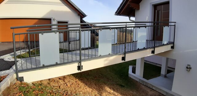 Innentreppe mit Metallgeländer und vertikaler Sprossenfüllung