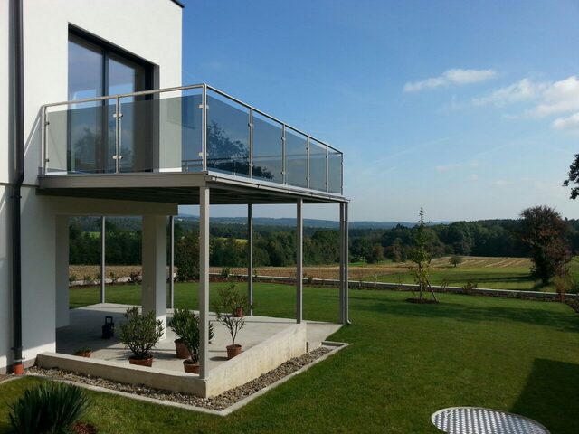 Wendeltreppe und Balkongeländer aus Holz und Metall an einem Landhaus