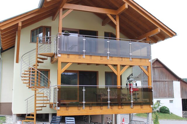 Balkongeländer mit horizontalen Metalllamellen an einem Giebelhaus