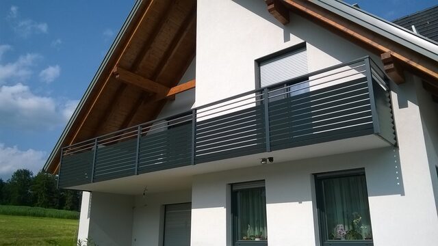 Balkongeländer mit horizontalen Lamellen und Metall-Handlauf im Detail