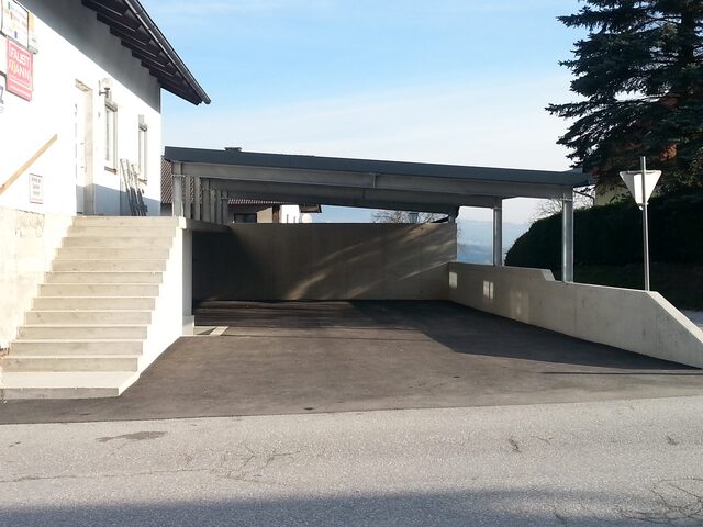 Carport aus Metall mit Betonwänden im Freien