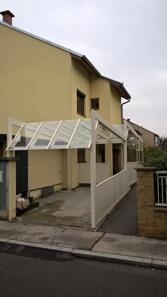 Carportdach aus Metall über einer Tiefgaragenzufahrt mit Ausblick