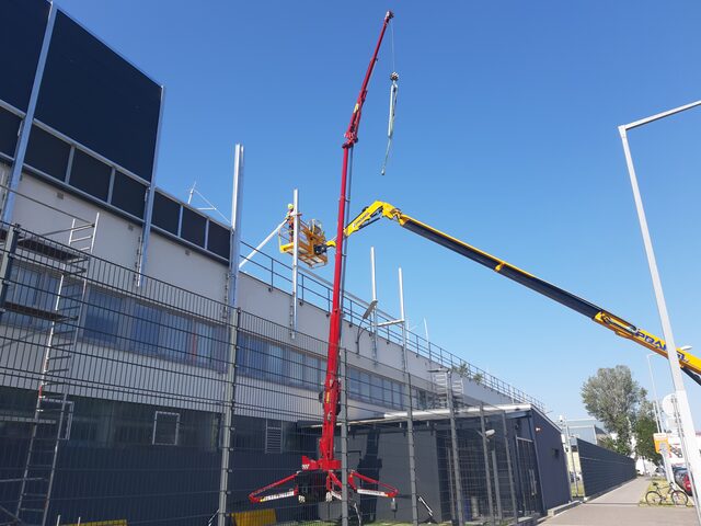 Kran im Einsatz an einer Werkshalle