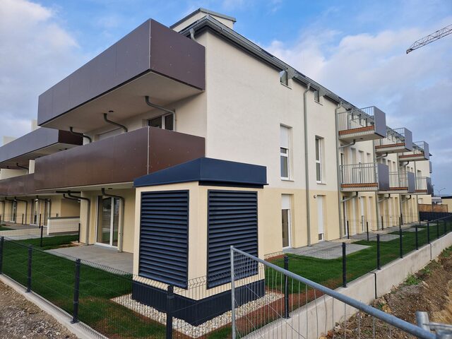 Mehrstöckiges Wohnhaus mit Glasbalkonen an einer Hanglage