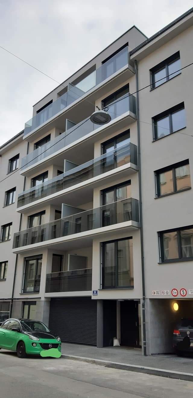 Mehrfamilienhaus mit Balkonen und Lüftungsverkleidung