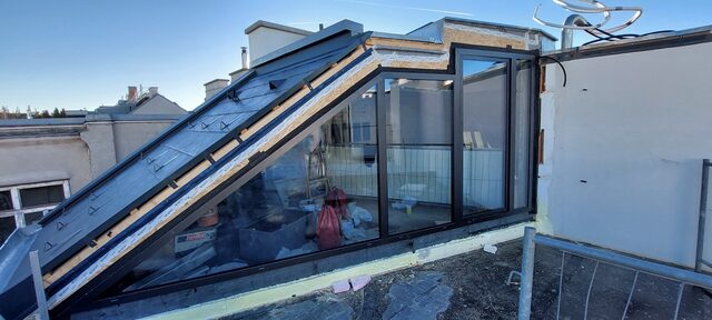 Rundbogenportal mit zweiflügeliger Tür aus Metall in ockergelber Fassade