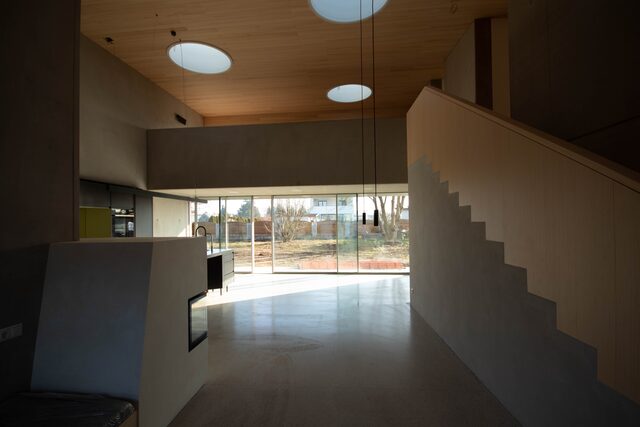 Moderner Wohnraum mit Holztreppe und Oberlichtern