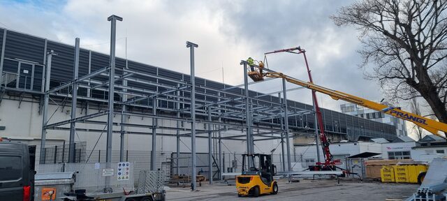 Stahlskelettbau einer Halle mit Kranfahrzeug bei der Montage