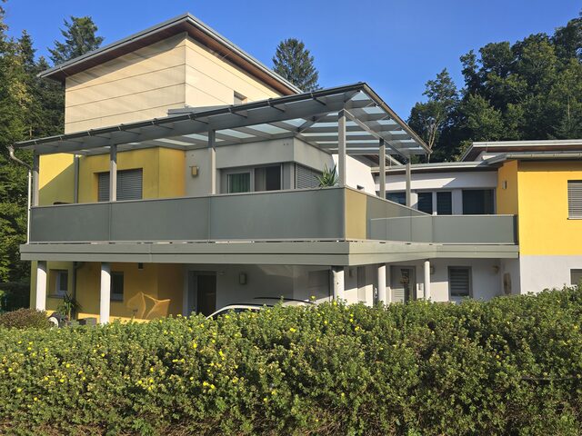 Pergolaartige Terrassenüberdachung mit Glaseindeckung über einem Balkon